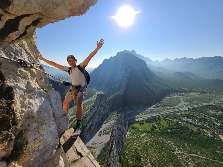 Persona en vía ferrata con vista de montaña